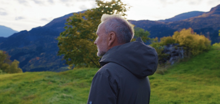 Person watching a lake surrounded by mountains. Person watching a lake surrounded by mountains.