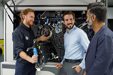 3 men performing support on a digital label press. 3 men performing support on a digital label press.