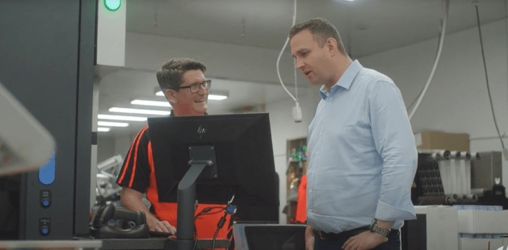Two people standing next to a computer Two people standing next to a computer